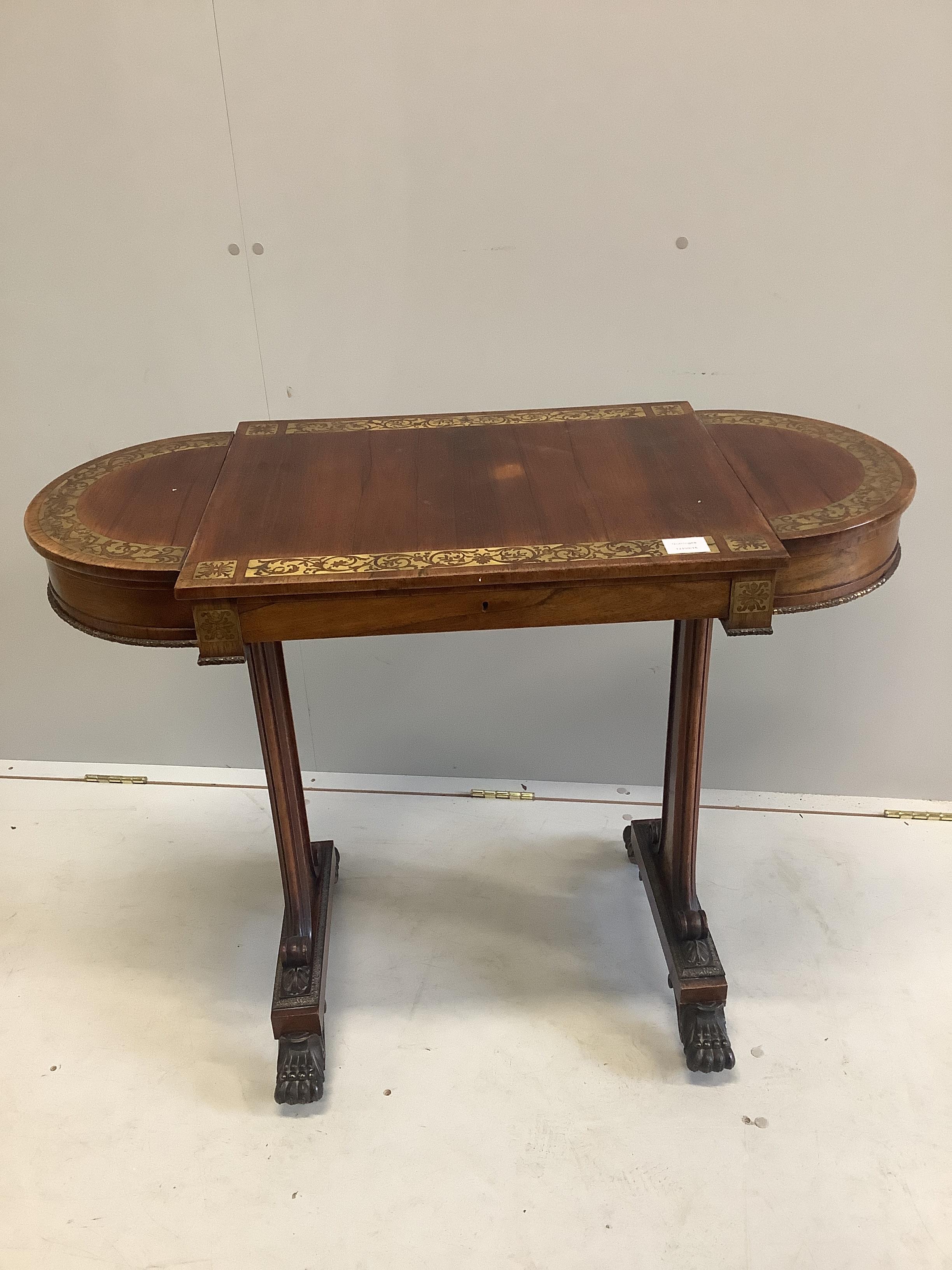 A Regency cut brass inlaid rosewood table with twin hinged flap top, lacks silks box, width 94cm, depth 46cm, height 73cm